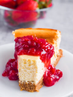 A slice of cheesecake with strawberry topping