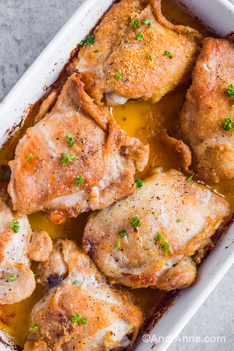Close up of cooked chicken thighs in baking dish.