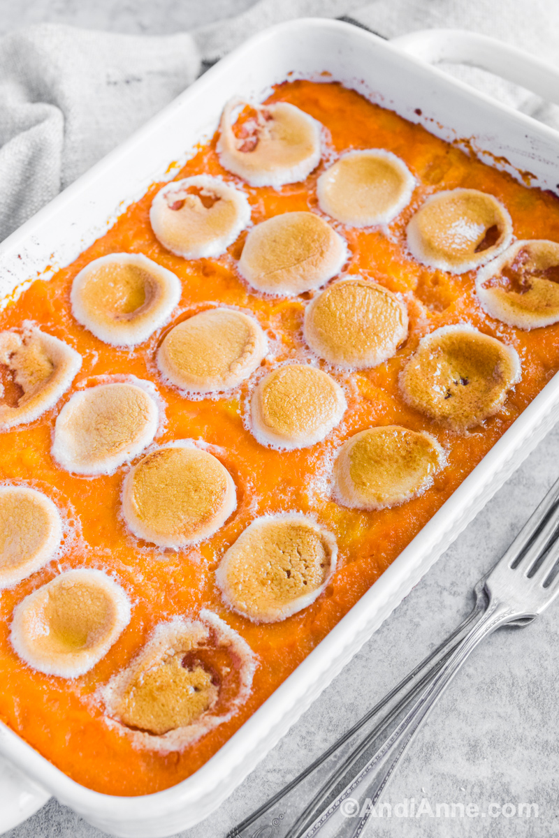 Side angle of sweet potato marshmallow casserole in a white dish.