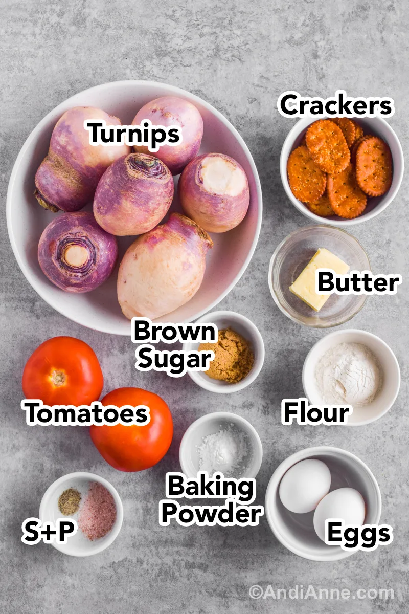 Recipe ingredients on a counter including a bowl of turnips, crackers, tomatoes, eggs, butter, flour and baking powder.