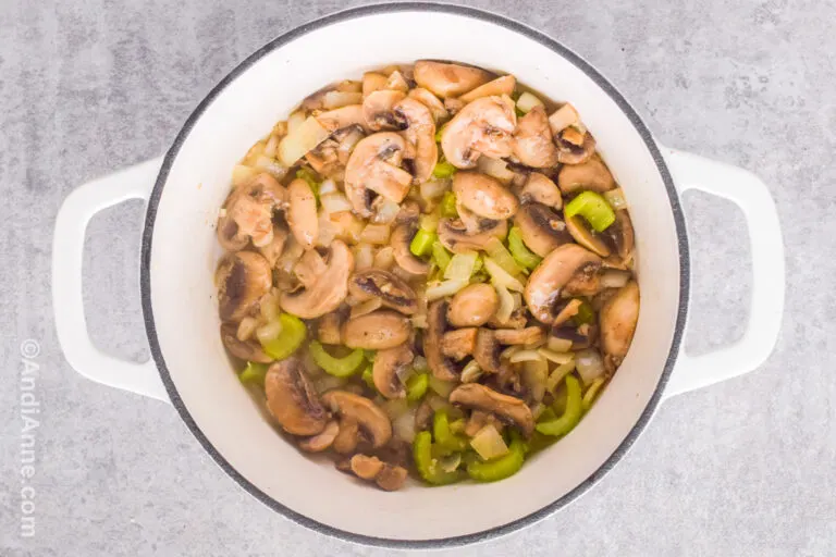 Cooked mushrooms and celery in a white bowl.