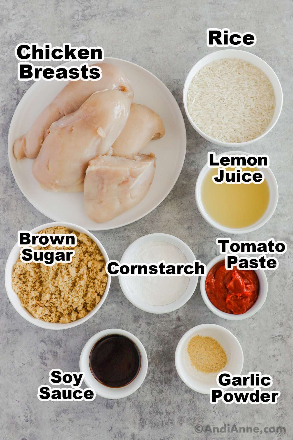 Recipe ingredients including bowls of lemon juice, brown sugar, cornstarch, tomato paste, soy sauce, garlic powder and raw chicken breasts