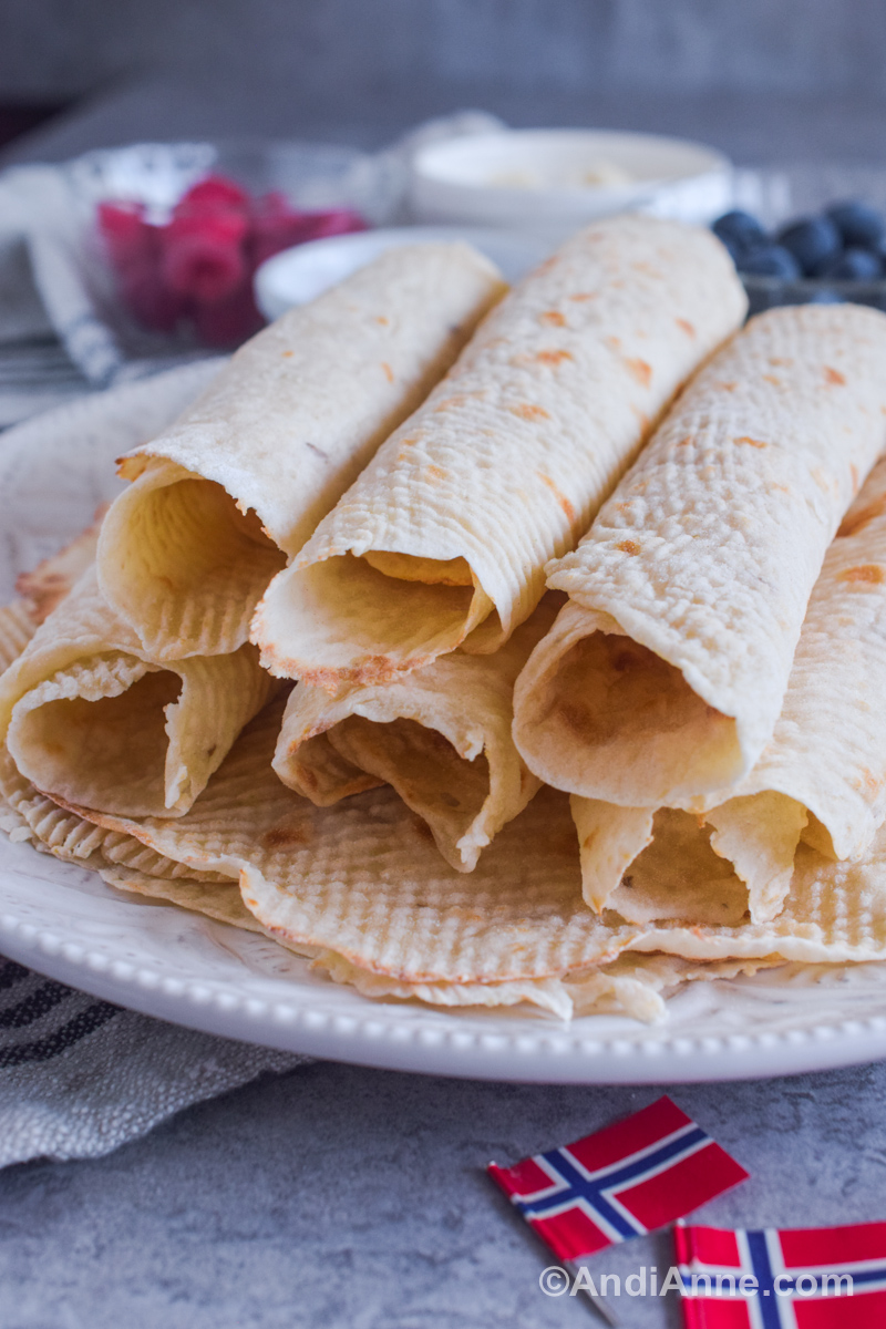 Rolls of lefse on a plate with small paper flags in the front.
