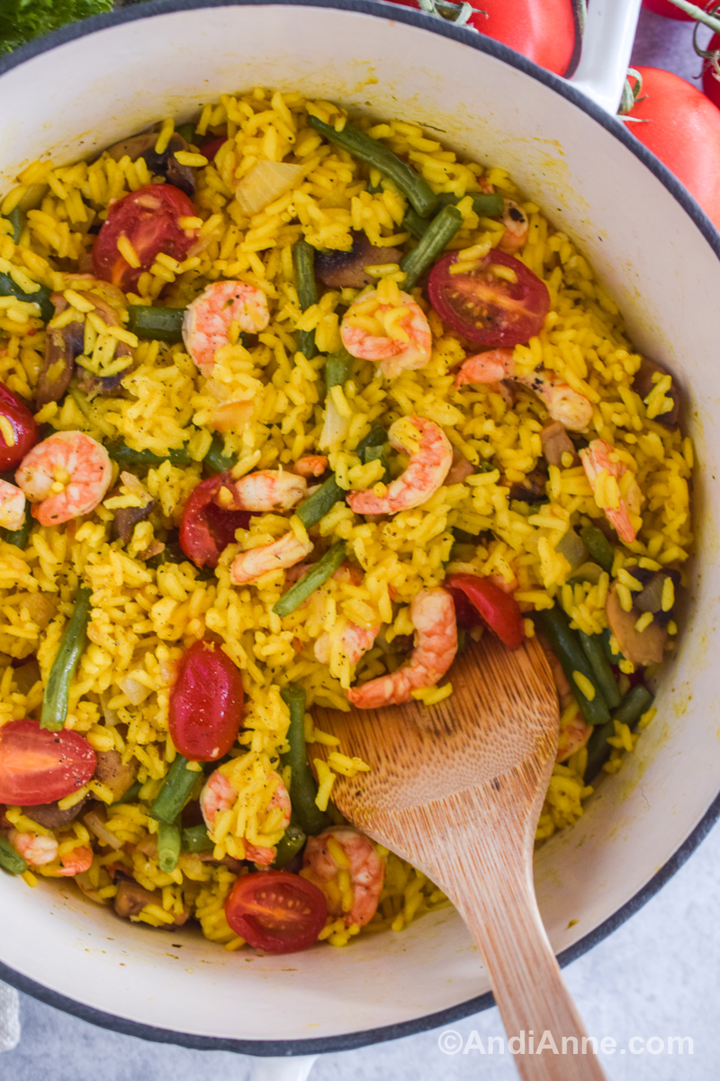 Close up of shrimp with turmeric rice recipe and sliced mushrooms, tomatoes and green beans. 