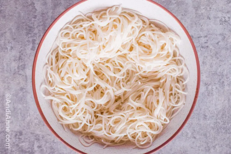 Cooked spaghetti noodles in a large white bowl.