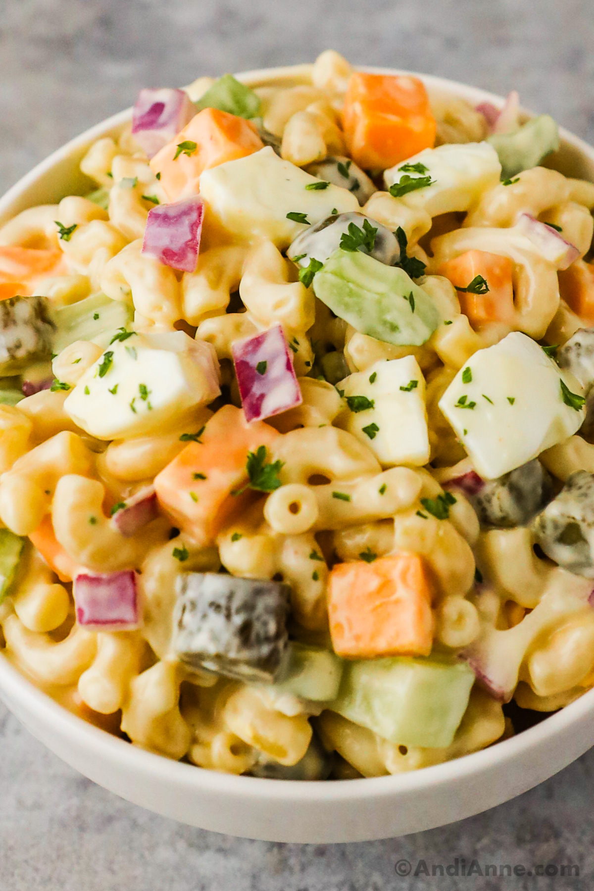 Close up of macaroni, eggs, celery and cheese in a creamy pasta salad.