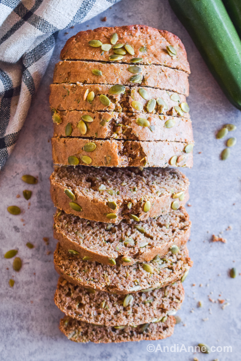 Slices of whole wheat zucchini bread stacked together on a counter.