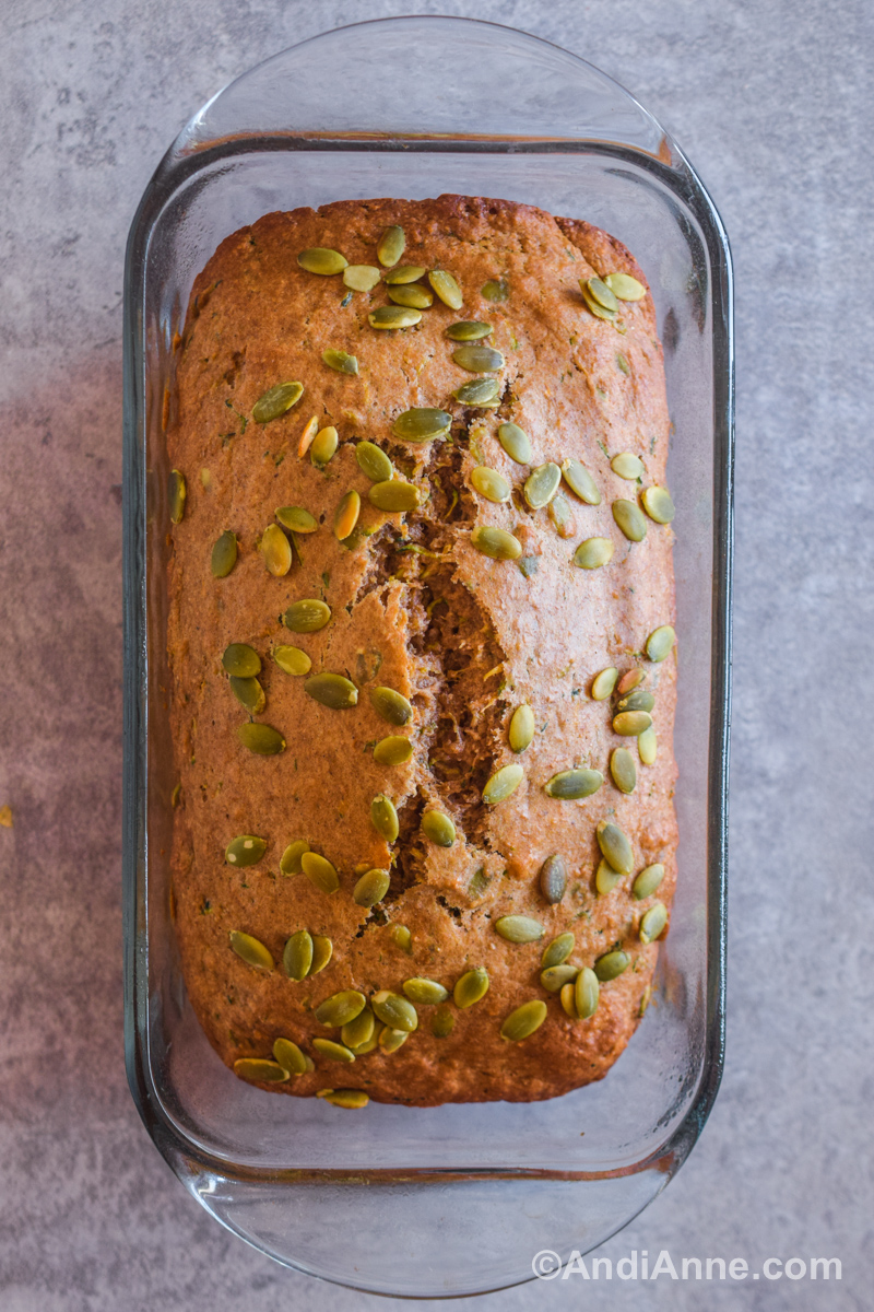 Looking down at a baked zucchini loaf with pumpkin seeds sprinkled on top.