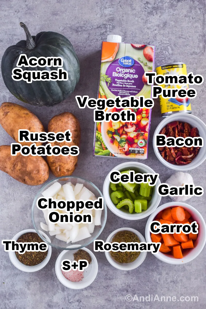 Recipe ingredients on a counter including a carton of broth, acorn squash, russet potatoes, canned tomato puree, and bowls with bacon, celery, carrots, onion, spices and garlic.
