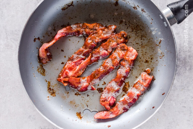 A frying pan with cooked bacon.