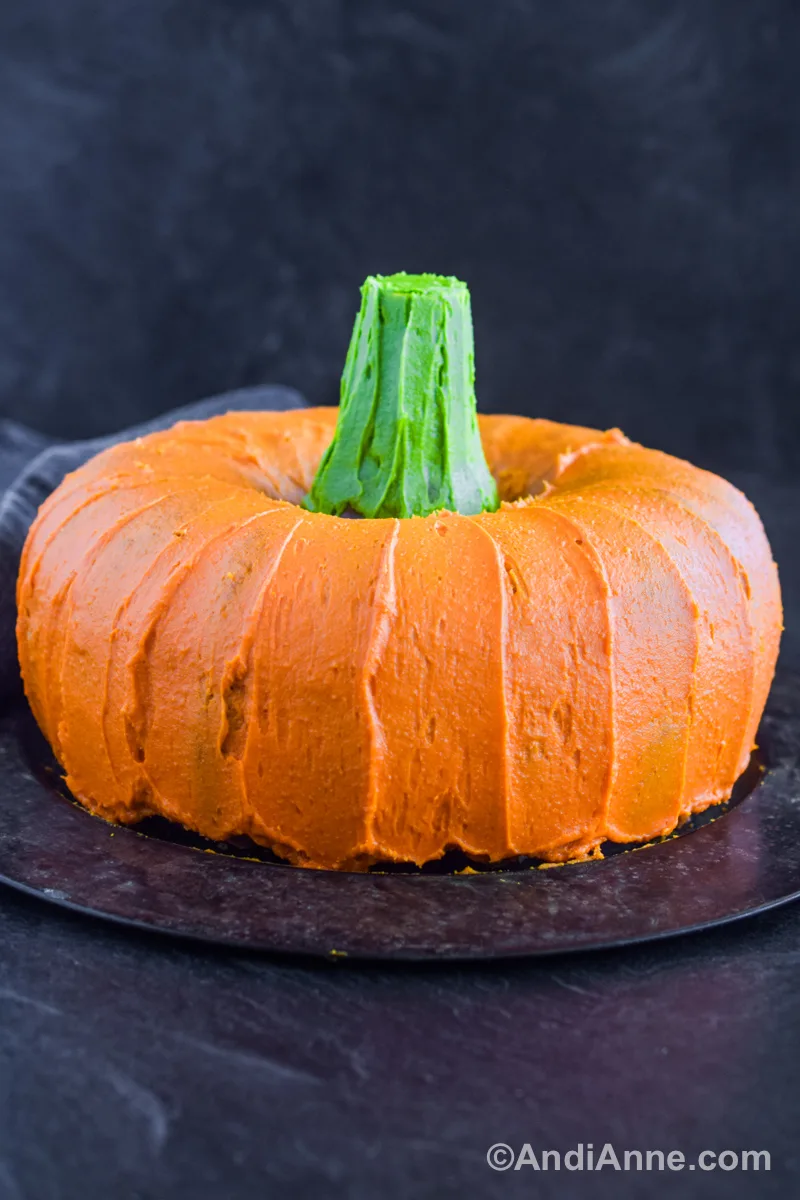 A pumpkin shaped cake with a black background.