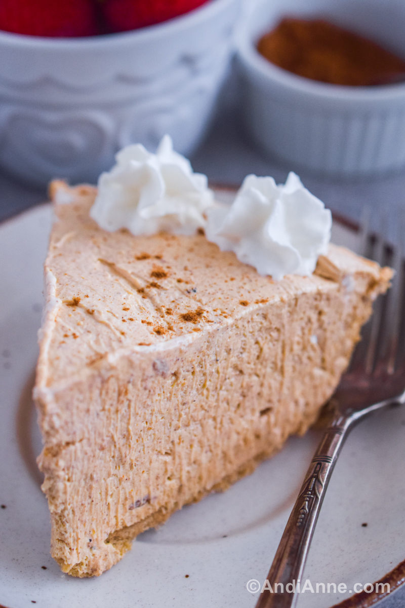 Close up of a slice of marshmallow pumpkin pie with a fork beside.