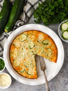 A white dish with zucchini pie and a fork.