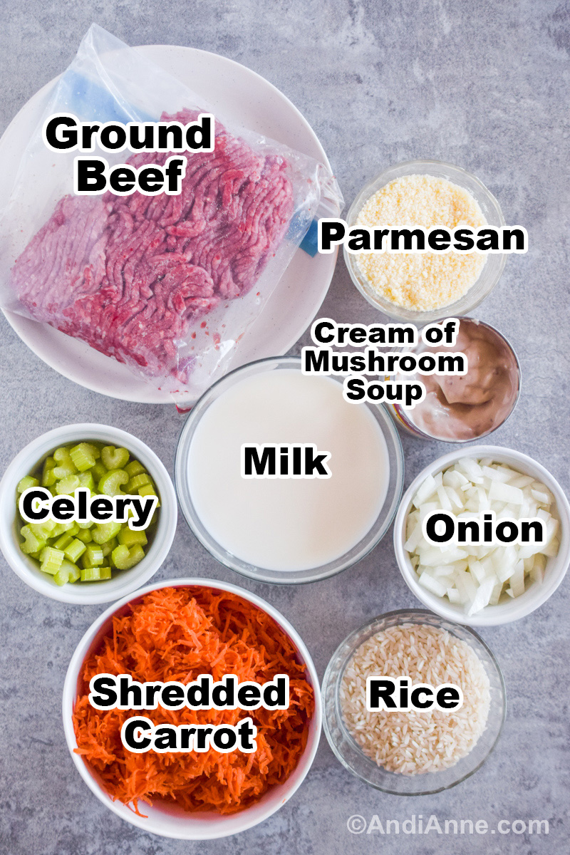 Recipe ingredients on a counter including ground beef, bowls of parmesan, celery, onion, shredded carrot, milk and rice.