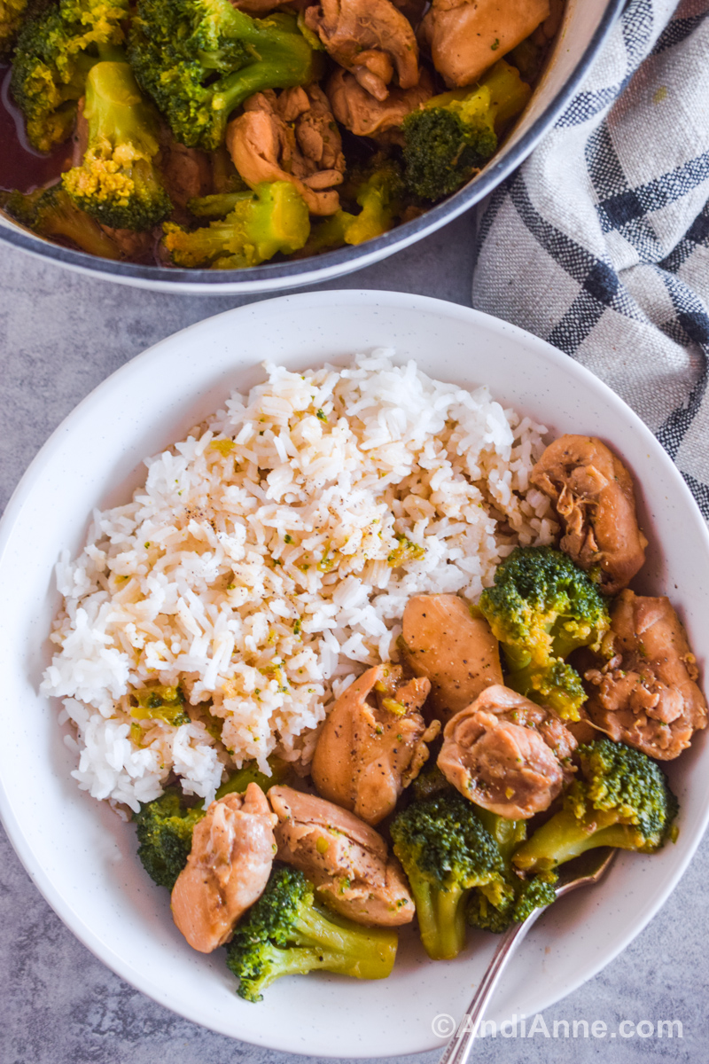 Chicken thighs and broccoli in soy sauce in a white plate with rice.