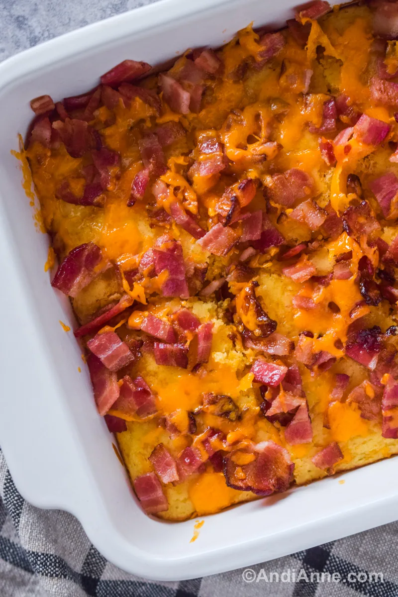 Close up of chopped bacon and melted cheddar cheese in a casserole dish.