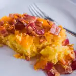 baked pancake with bacon and cheese on a white plate.