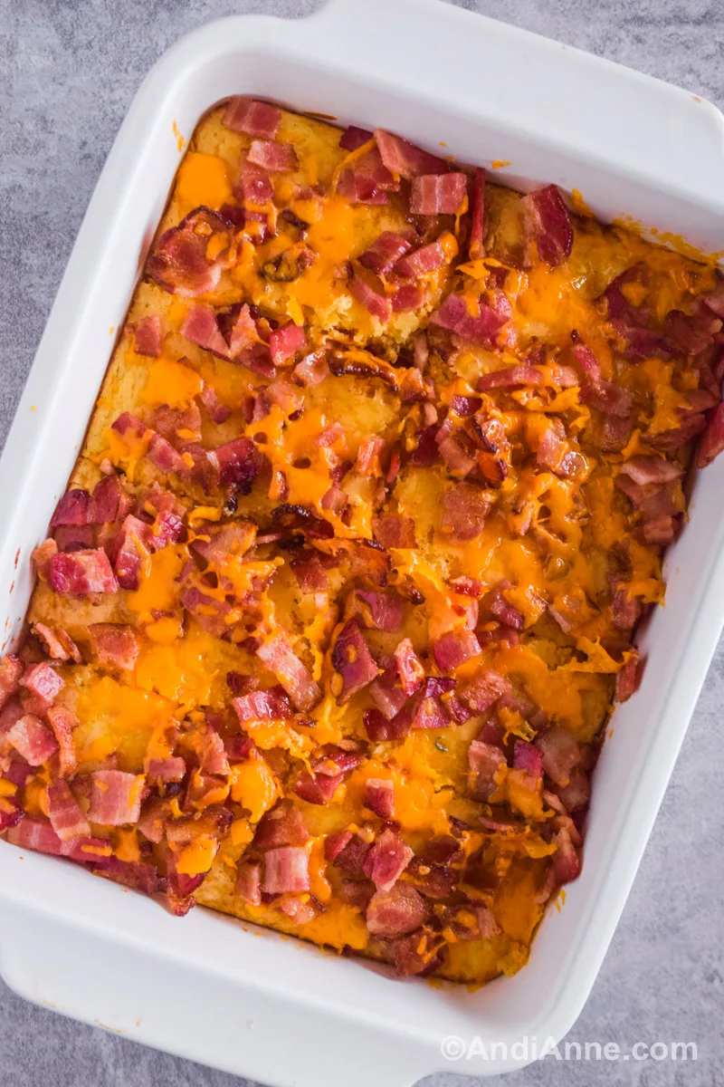 Looking down at a white casserole dish with bacon and cheese pancake recipe inside.