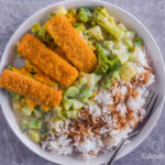 fish sticks, rice and broccoli cheese mixture on a white plate