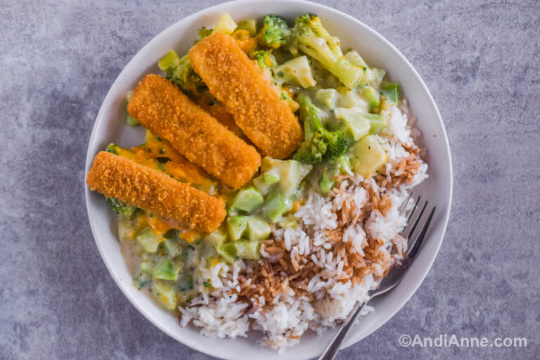 fish sticks, rice and broccoli cheese mixture on a white plate