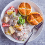 A white plate with chicken pot pie and biscuit recipe on top.