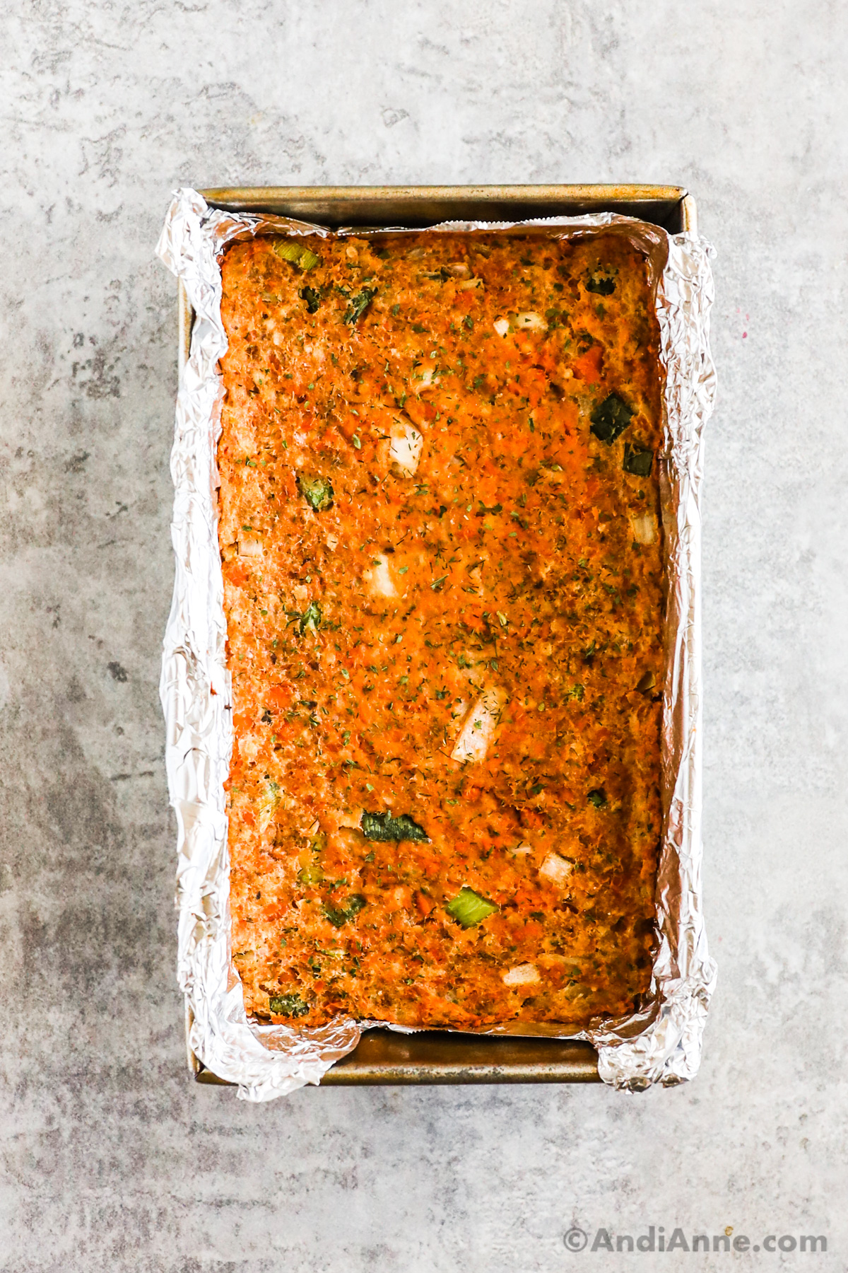 Close up of baked salmon loaf in a loaf pan.