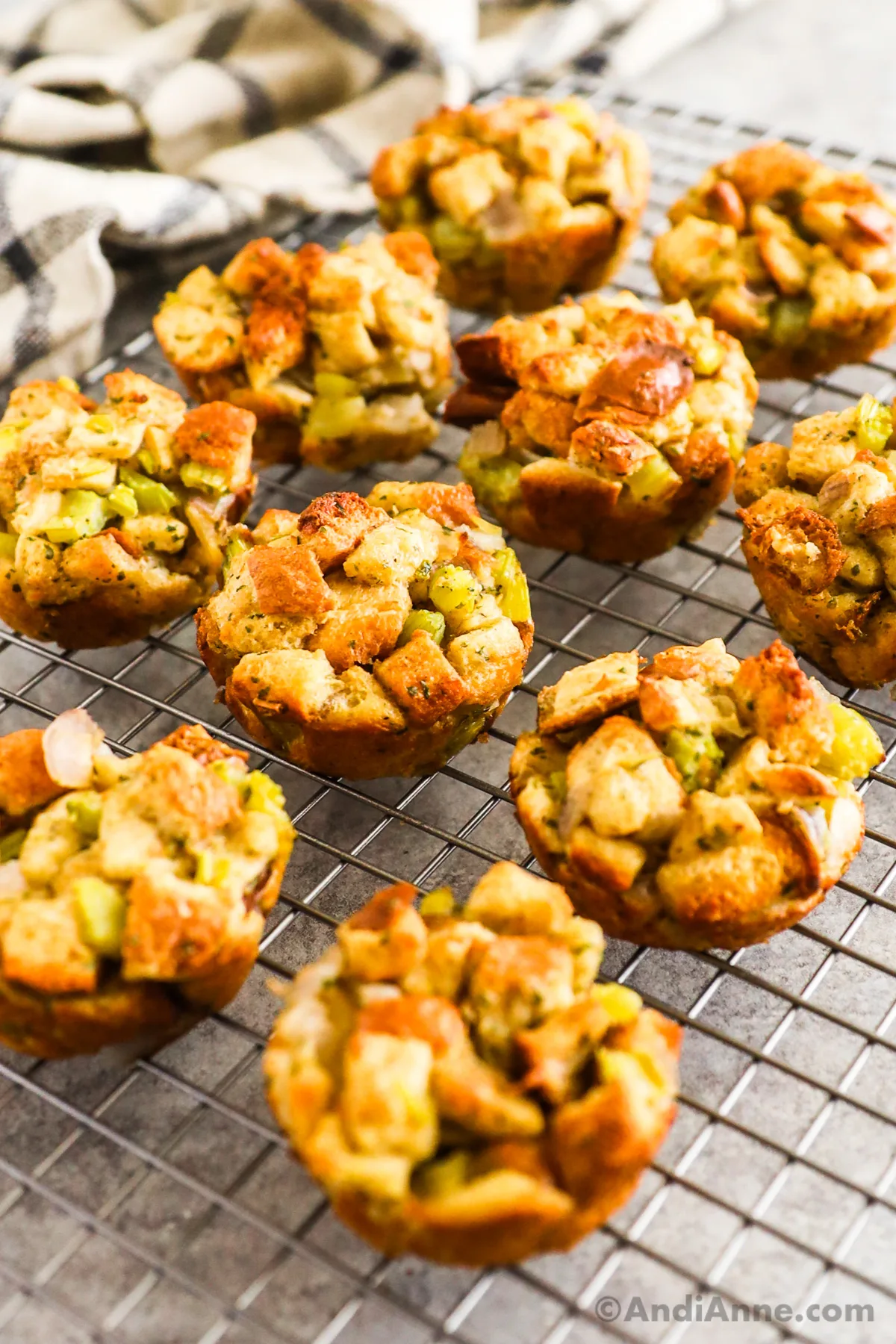 Stuffing muffins on a rack with a kitchen towel behind.