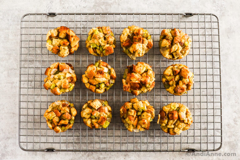 A cooling rack with 12 stuffing muffins on it.