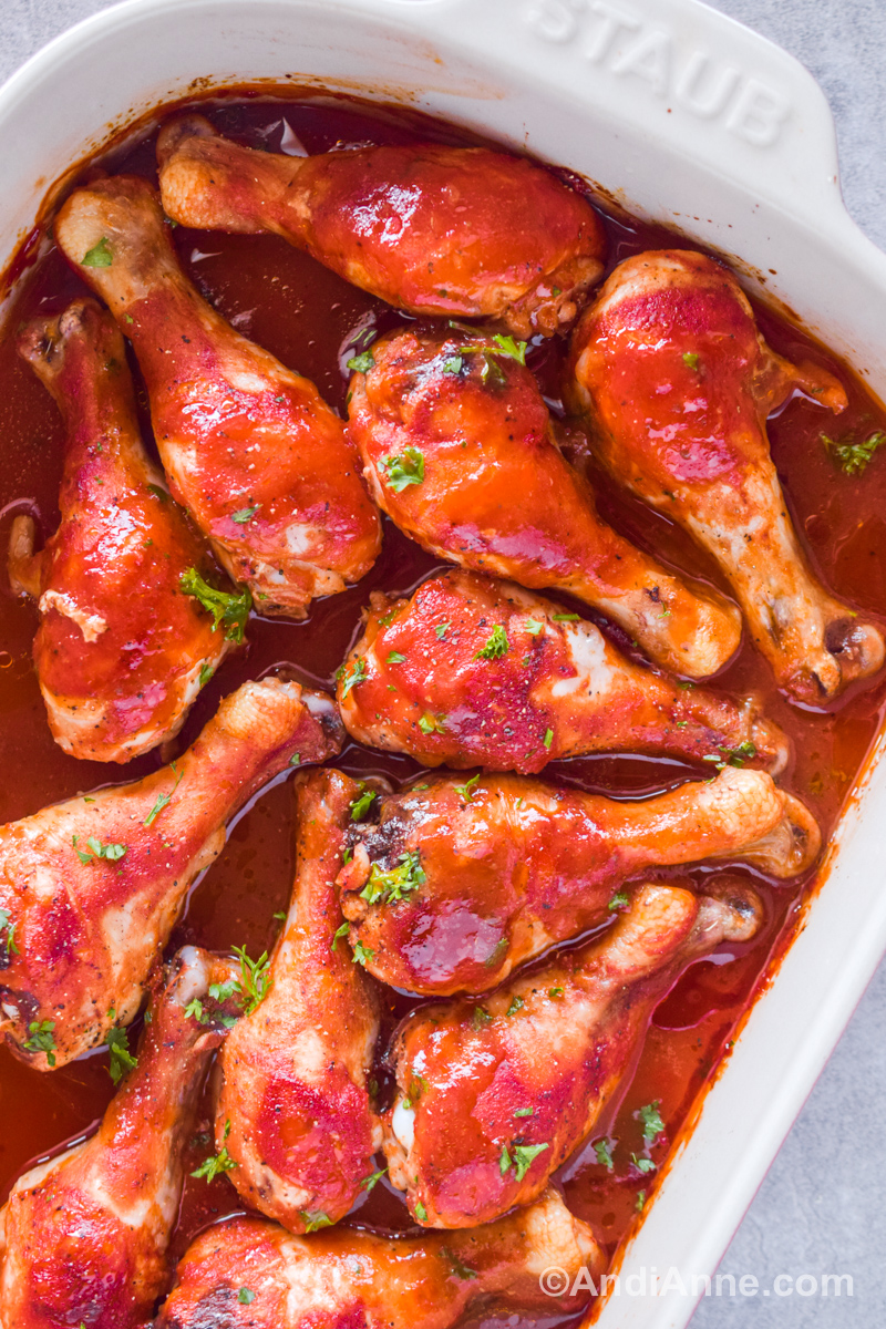 Chicken legs covered in sweet and sour sauce in a casserole dish.