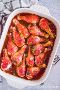 sweet and sour chicken legs in a white casserole dish