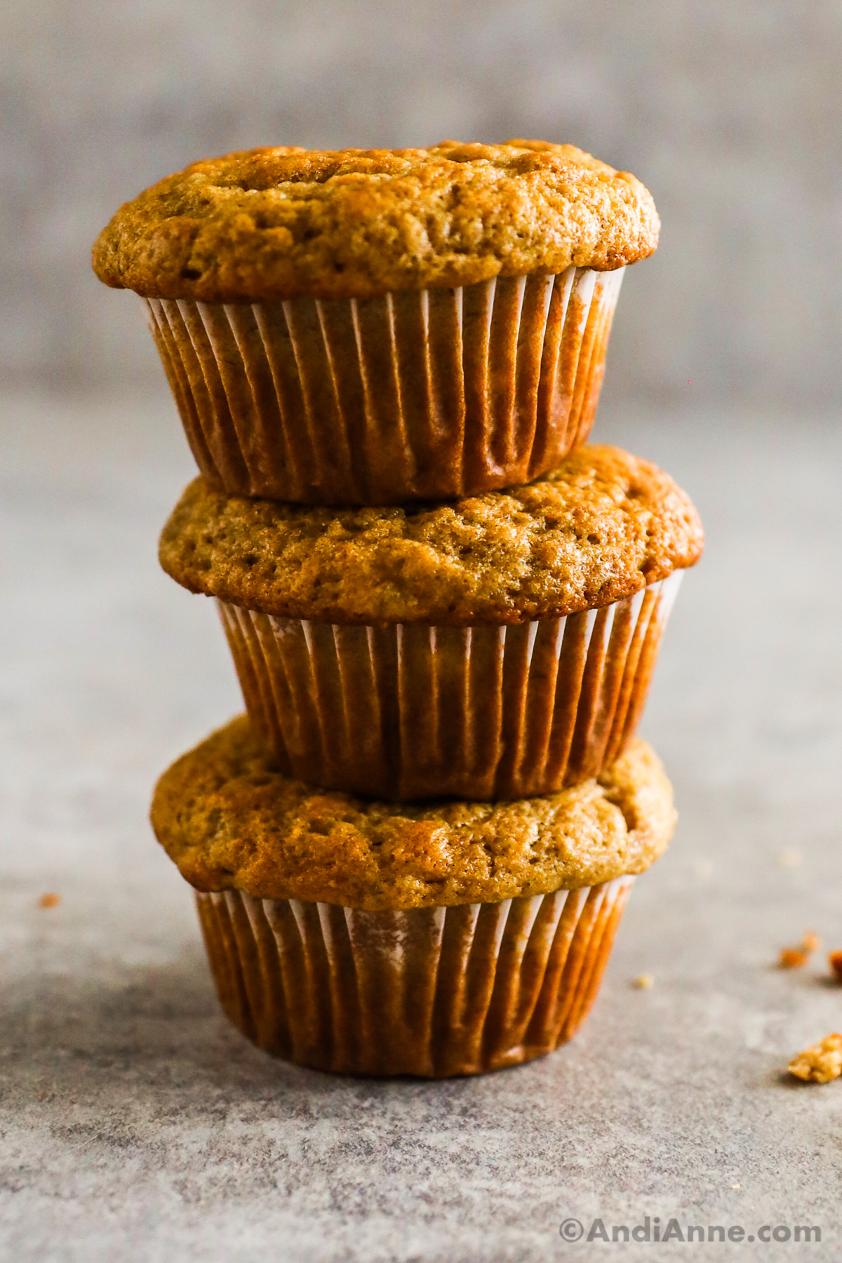 Three banana bread muffins piled on top of eachother.