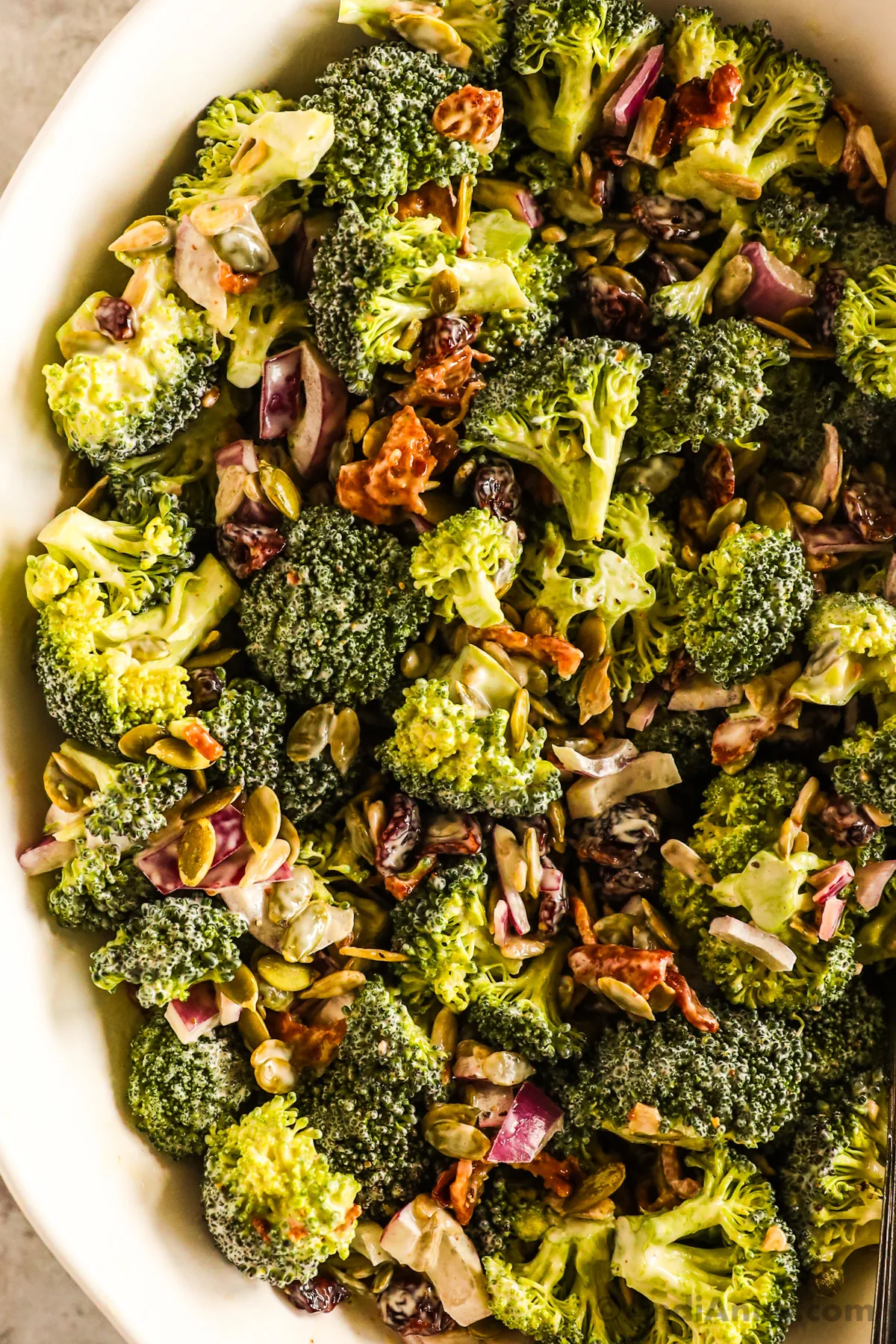 Close up of broccoli crunch salad with bacon, onion and seeds.