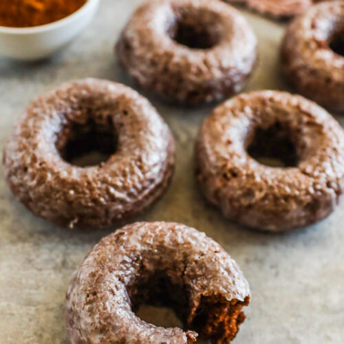 Chocolate baked donuts on a counter.
