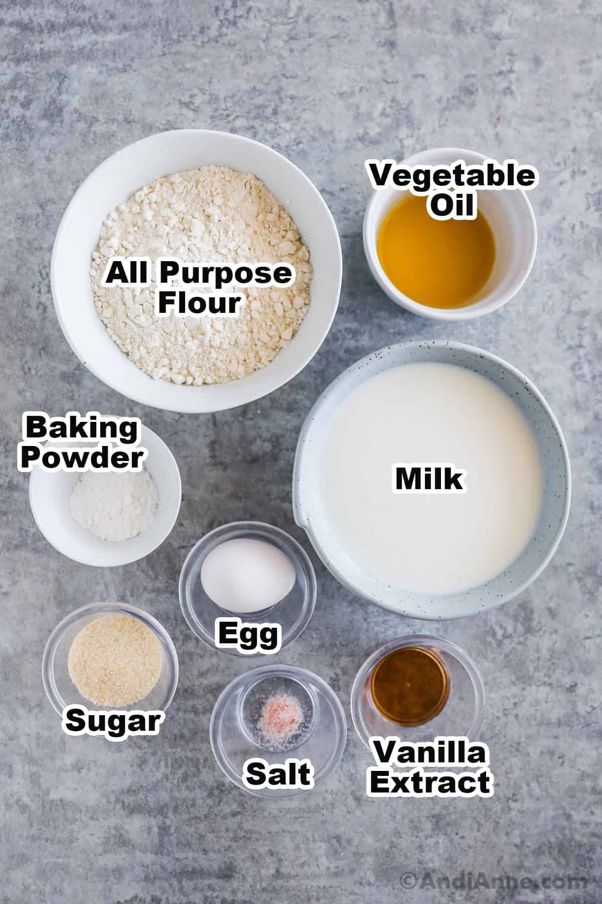 Bowls of ingredients including flour, vegetable oil, baking powder, milk, egg, sugar, salt and vanilla extract.