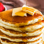 Stack of fluffy pancakes with butter and maple syrup and the text that reads "extra fluffy homemade pancakes"
