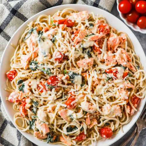 A bowl of creamy pasta with salmon and tomatoes