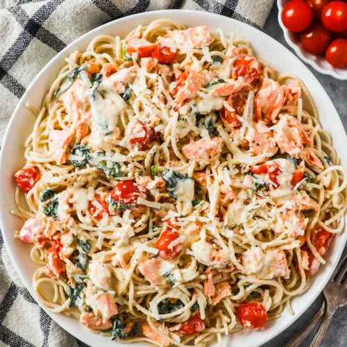 A bowl of creamy pasta with salmon and tomatoes