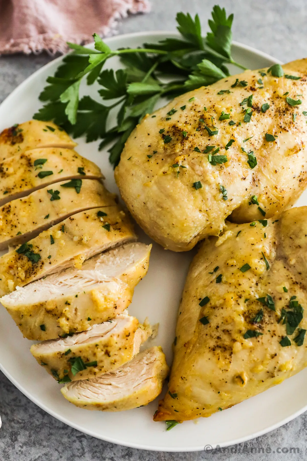 Three honey mustard chicken breasts on a plate, one sliced.
