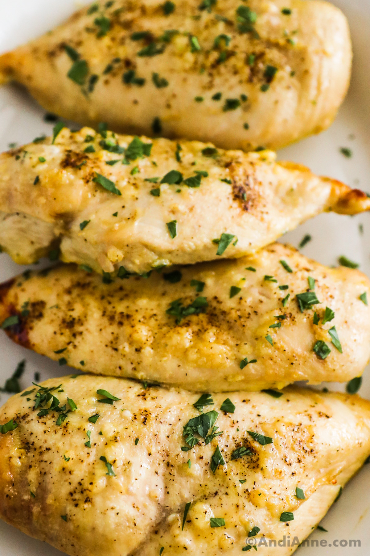 Close up of honey mustard chicken breasts with chopped parsley.