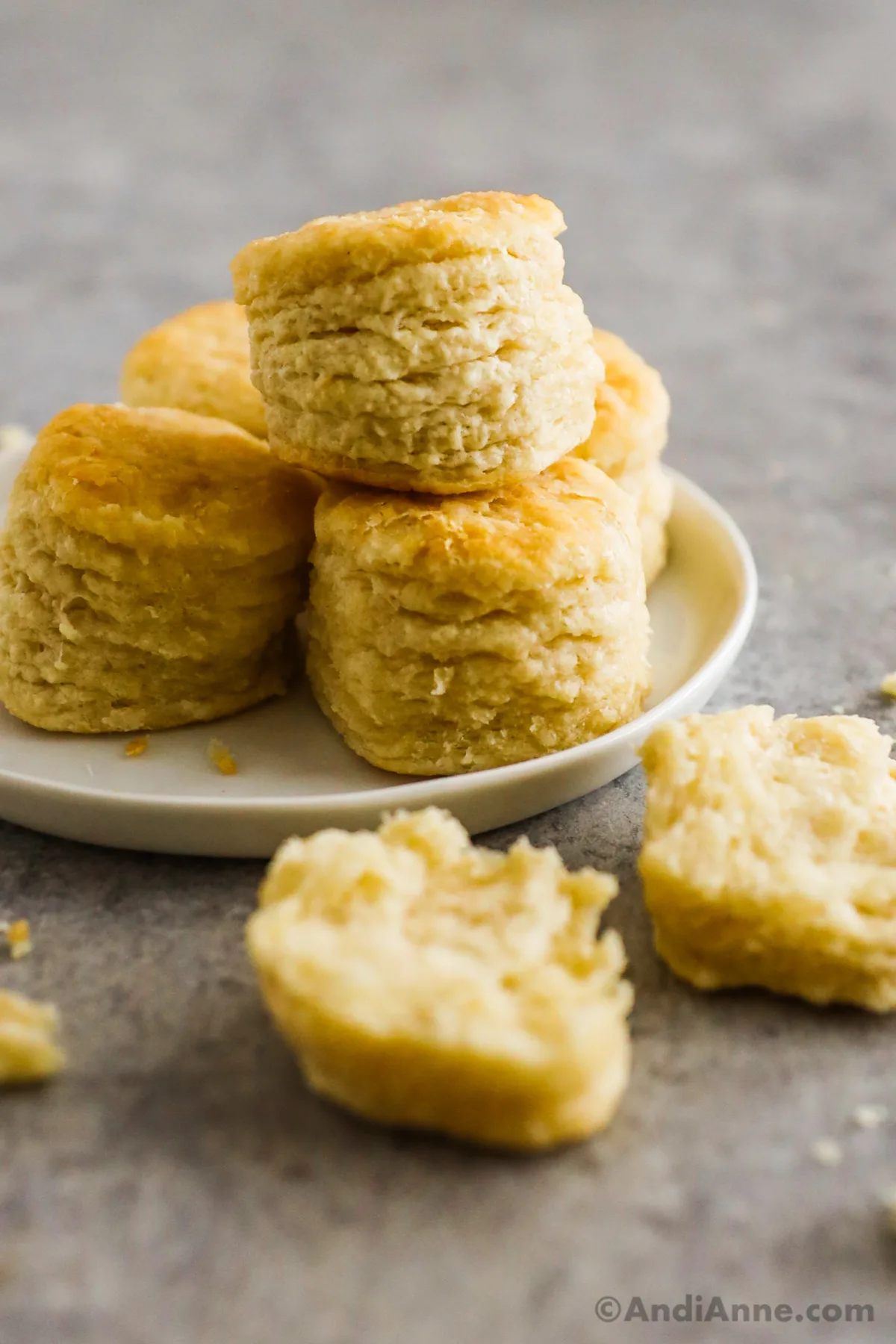 A few biscuits on a plate with one in the front.