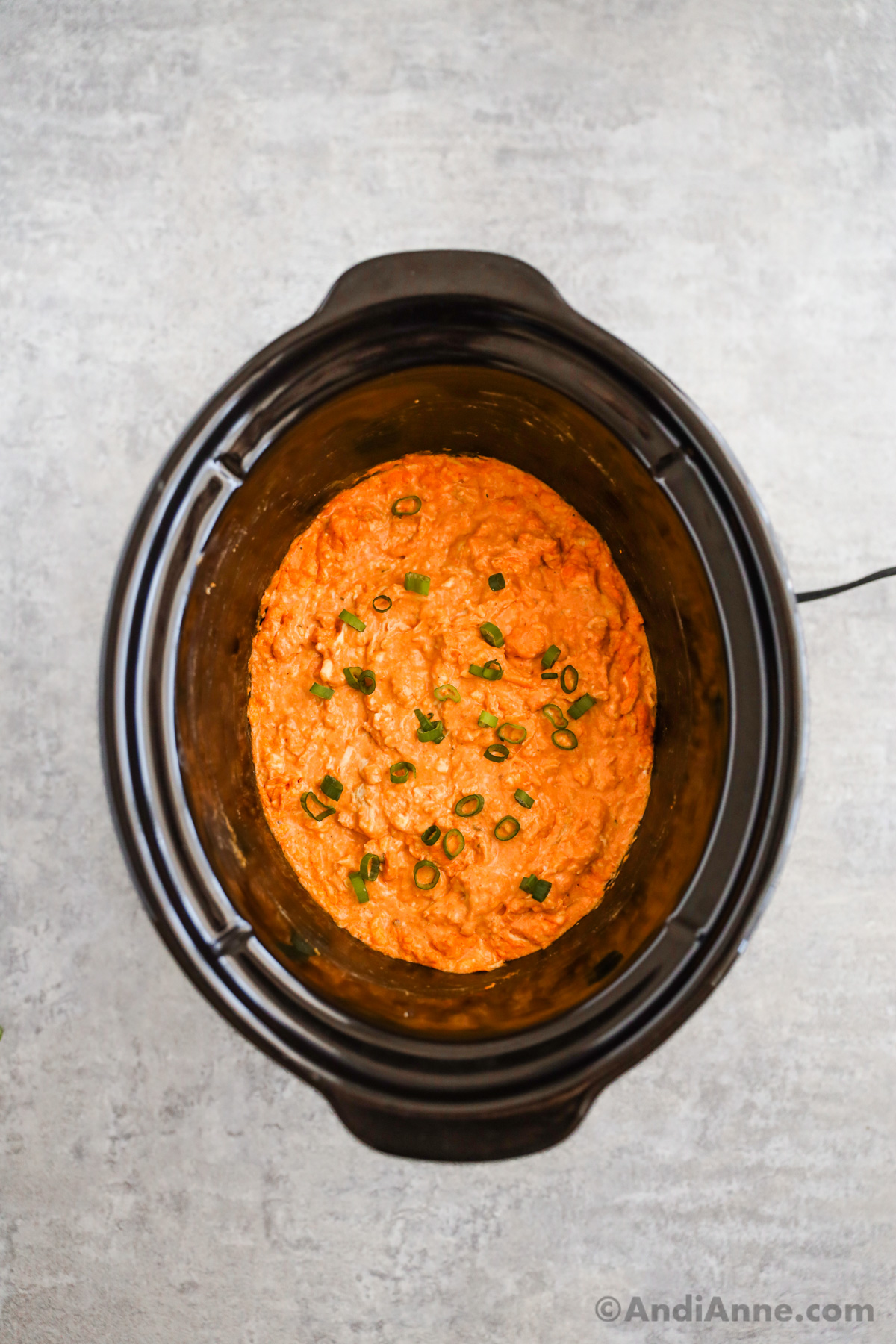 Looking into the slow cooker with buffalo chicken dip inside.
