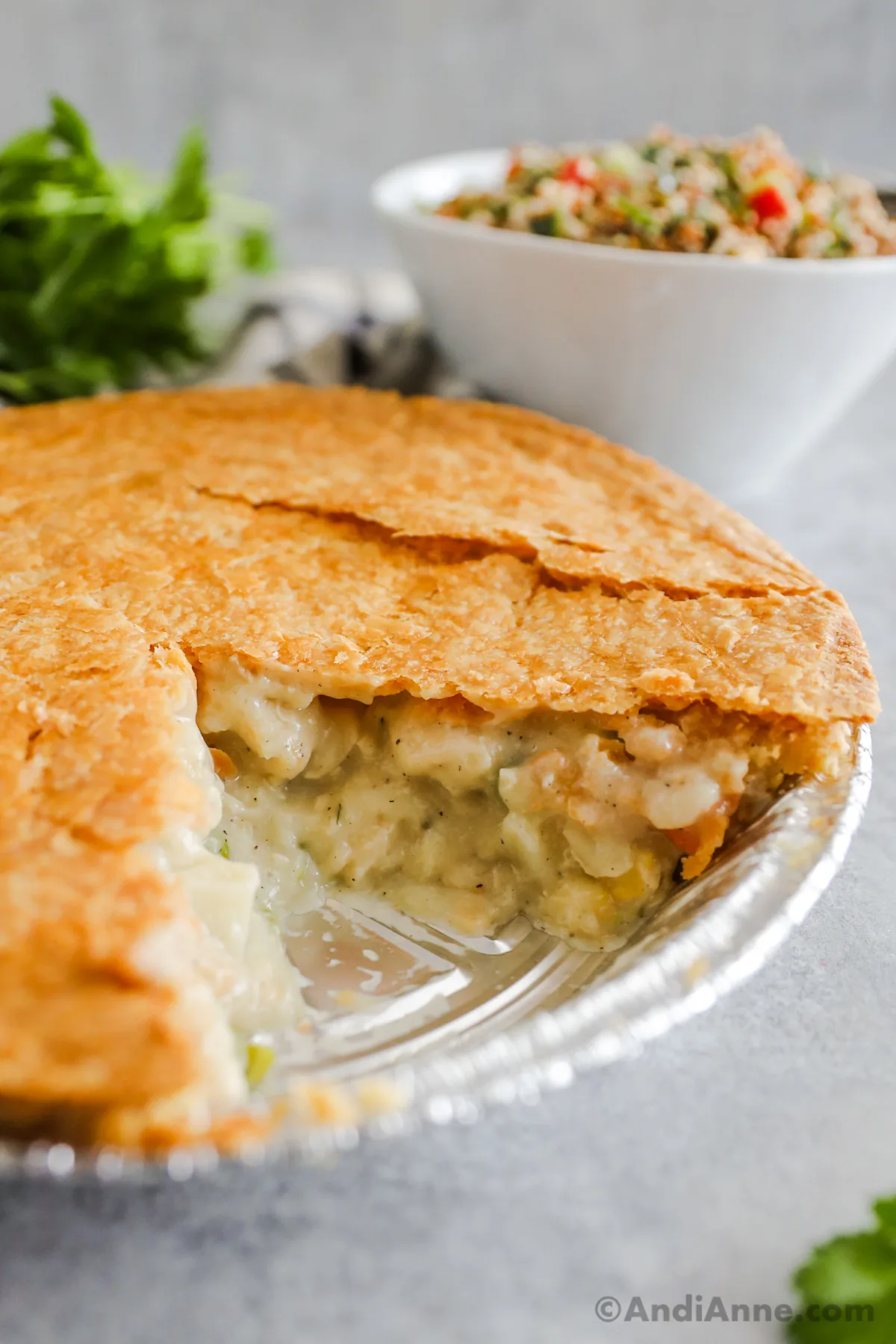 Looking at the filling inside a chicken pot pie on a foil pie plate.