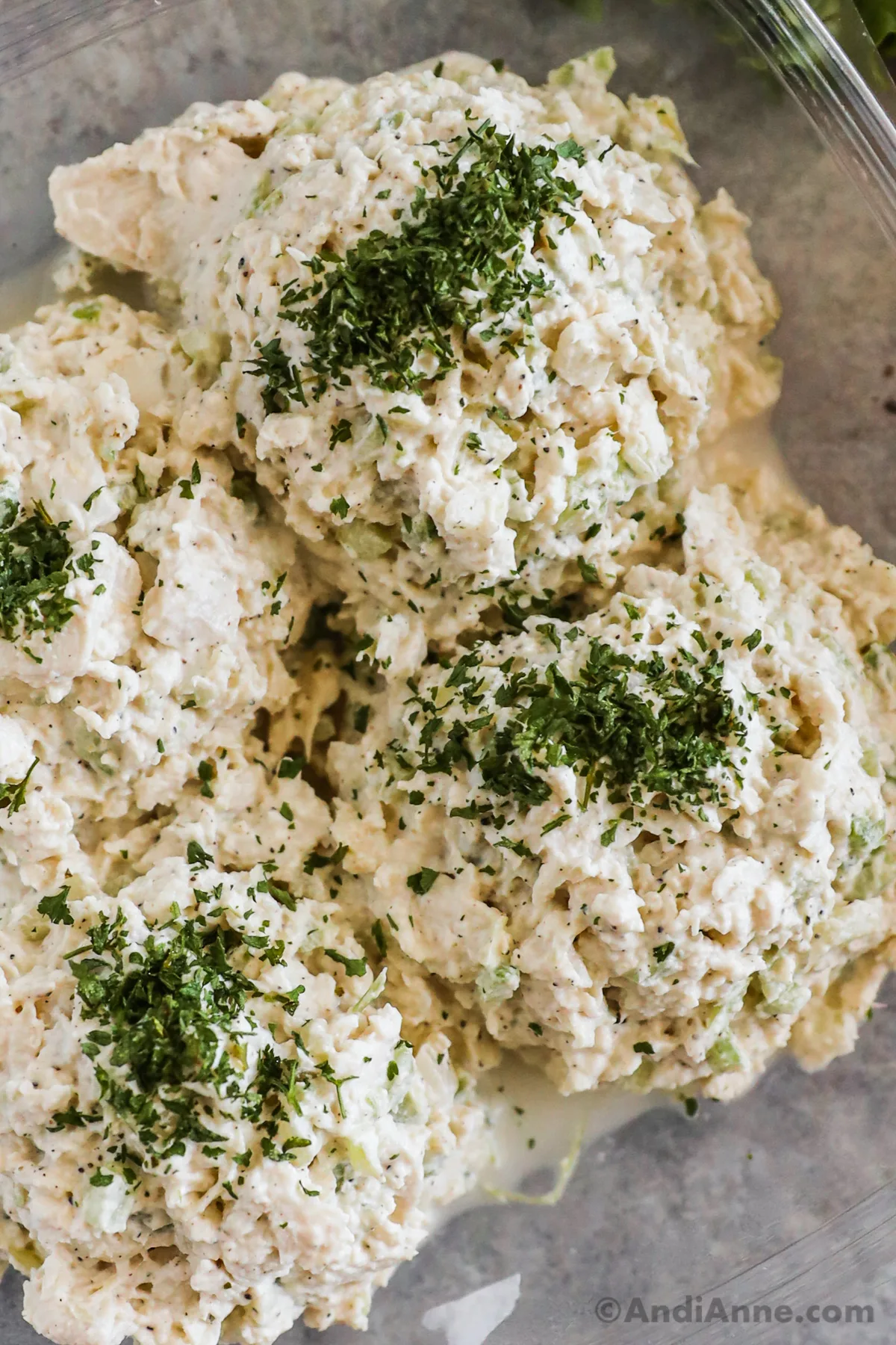 Close up of chicken salad topped with chopped parsley.