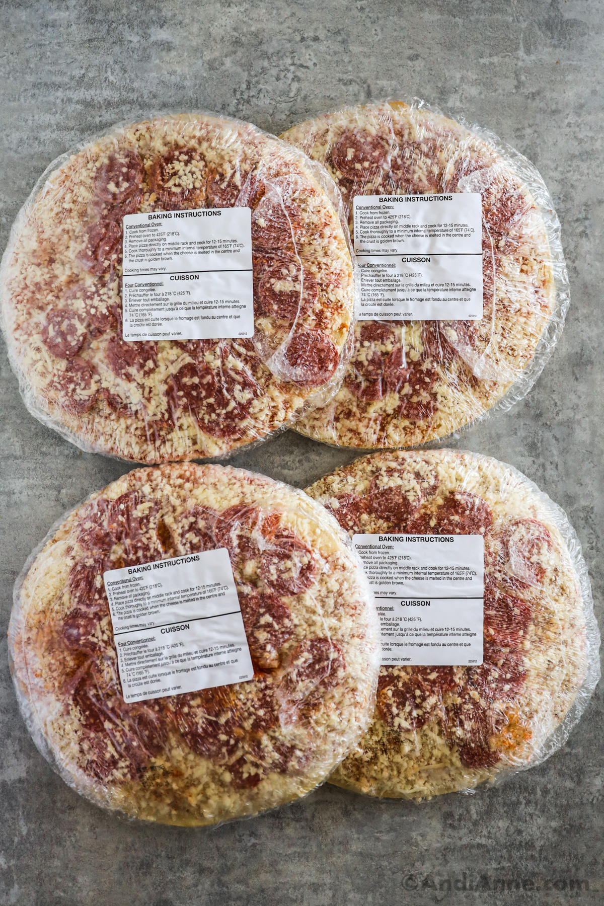 Four frozen pepperoni pizzas wrapped in packaging with baking instruction labels.