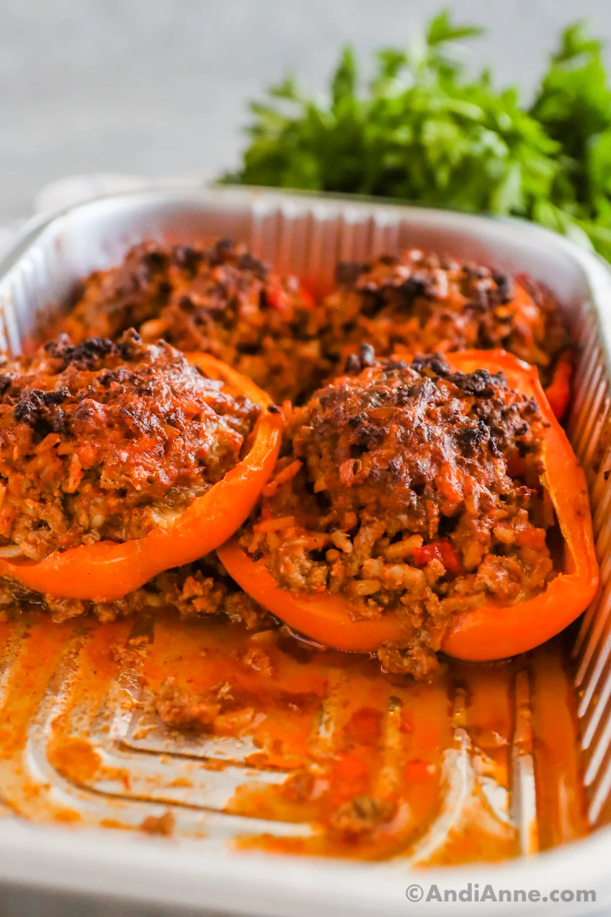 Baked stuffed bell peppers in a foil tray.
