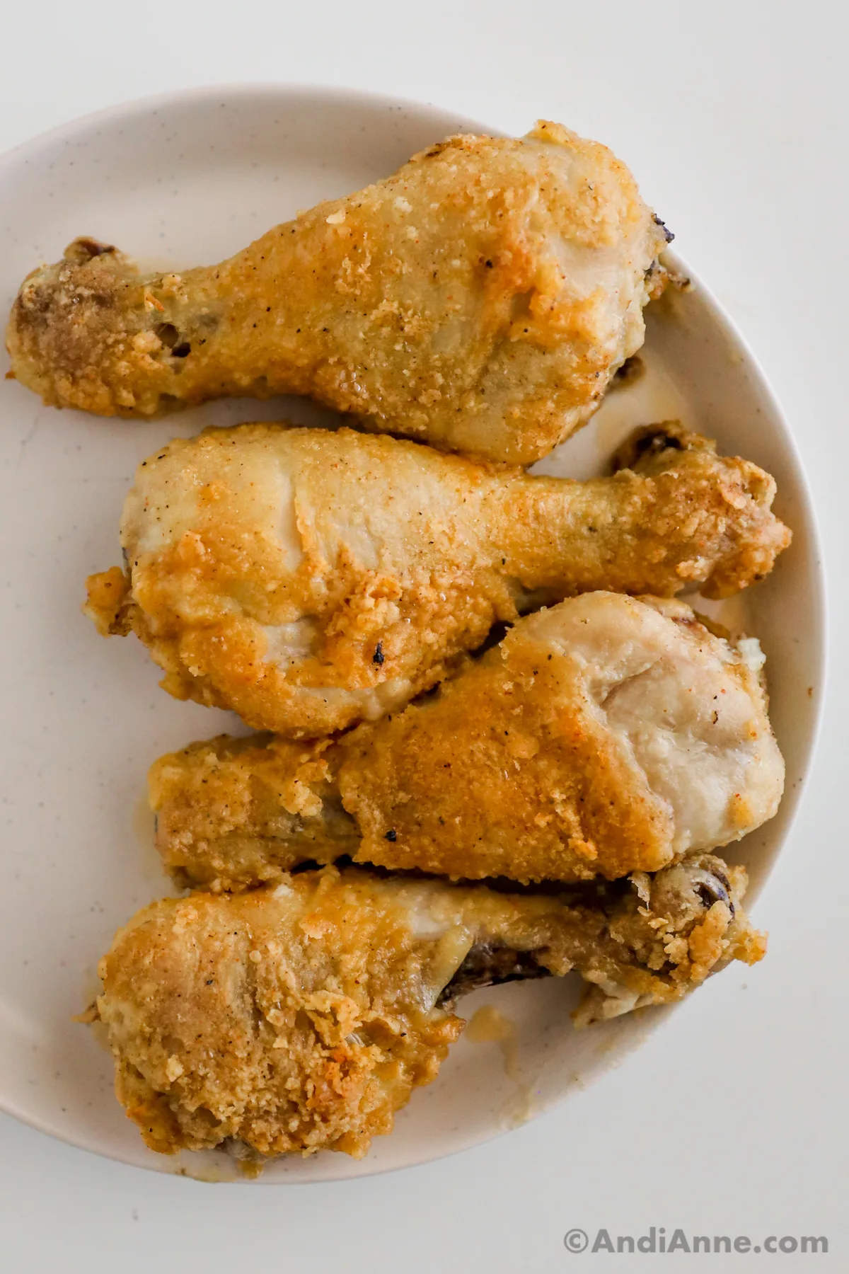 Close up of four fried chicken legs.