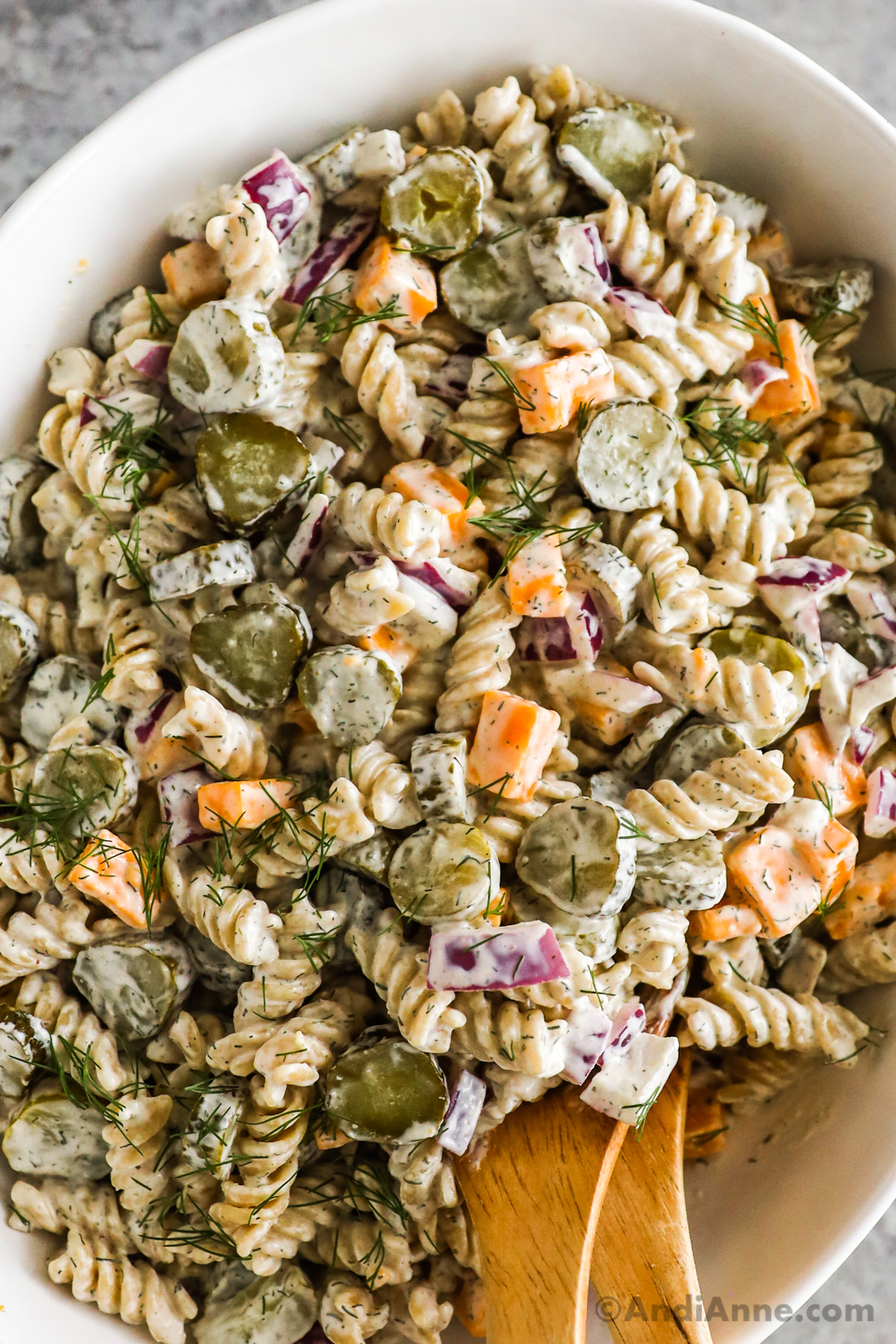 Close up of pasta, cheese, pickles and dill in the cold dill pickle pasta salad. 