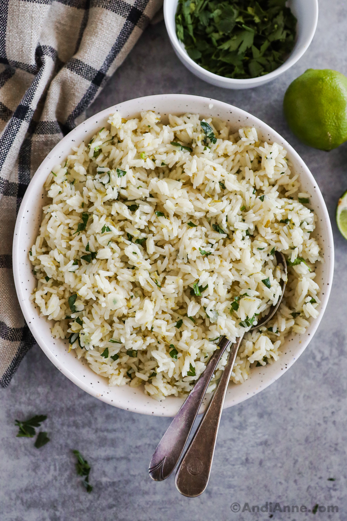 A bowl of cilantro lime rice with two spoons. 