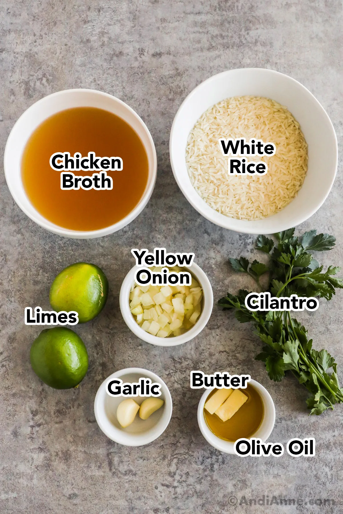 Recipe ingredients including bowls of broth, rice, onion, garlic and onion. Fresh limes and cilantro.