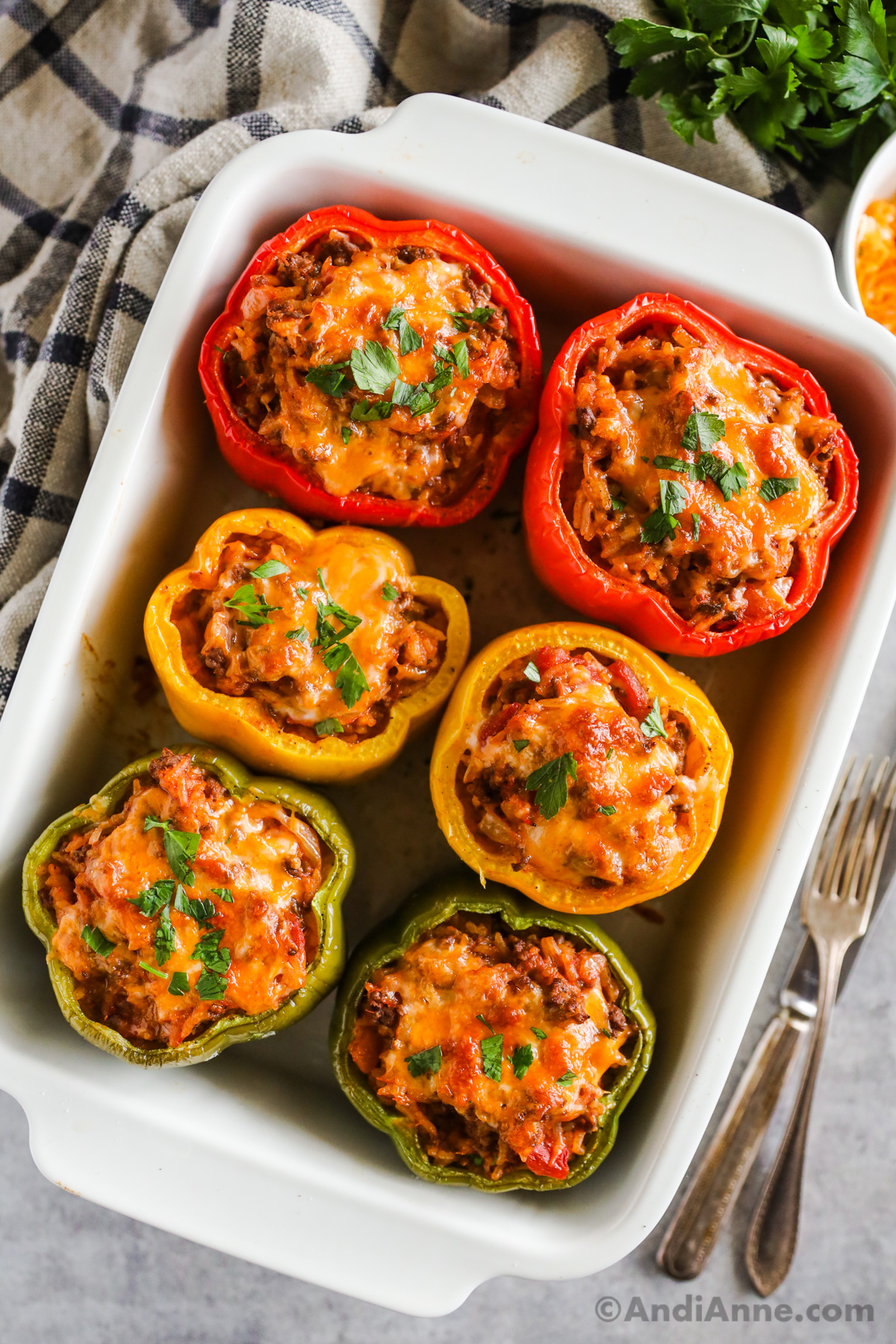 Six stuffed bell peppers sitting in a white baking dish.